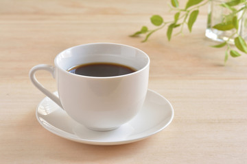 a cup of coffee on a wooden table
