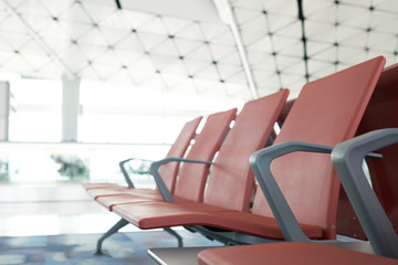 Waiting chairs of passengers in red airport. The background is the atmosphere in the airport. For passengers waiting to leave or may lie in the airport. as background travel concept with copy space.
