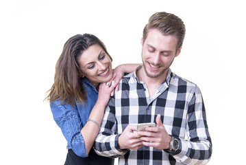 Young couple in love, married or in a relationship, browsing social media posts on a cell phone