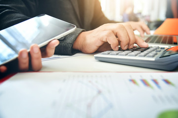 Businessman hand are using a calculator.