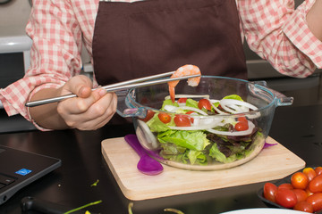 beautiful woman cooking in new kitchen making healthy food with vegetables.