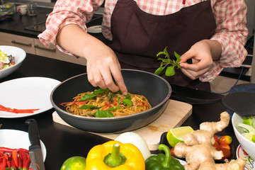 beautiful woman cooking in new kitchen making healthy food with vegetables.