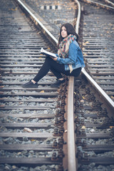 girl reading on the train tracks