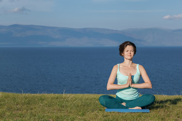 Fototapeta na wymiar Woman meditating at seaside