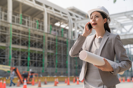 female engineer speak on the phone at building site.