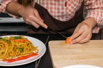 beautiful woman cooking in new kitchen making healthy food with vegetables.