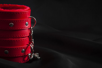 Bondage, adult sex games and BDSM lifestyle concept with close up on a pair of red leather...