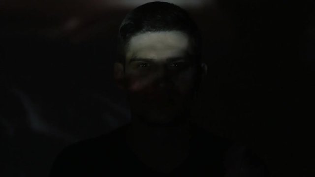 Timelapce Portrait of young man watching a video or film on TV or a computer monitor. Reflection on his face