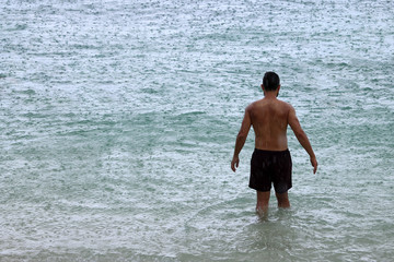 Fototapeta premium Tourists enjoy activities while raining on the beach,Rainy season in Thailand.