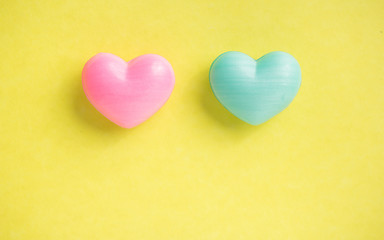 Couple of heart shapes over yellow table. Valentines day symbol for background use. Love, romance, and passion.