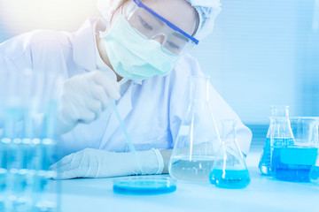 Asian women scientist with test tube making research in clinical laboratory.Science, chemistry, technology, biology and people concept