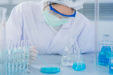 Asian women scientist with test tube making research in clinical laboratory.Science, chemistry, technology, biology and people concept