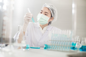 Professional distinguished Science specialist at work.Young Asian scientist with test tube making research in clinical laboratory.Innovative technologies in science and medicine