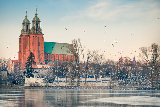 Gniezno, Poland; evening view to the gothic cathedral upon the frozen lake. Winter.