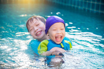 Fototapeta na wymiar Asian children in swimming suit playing in swimming pool