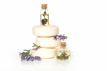 Obraz na płótnie Canvas Essential lavender oil set in transparent bottle, soap with lavender extract, and sprigs of fresh lavender on white background.Pure Organic Botanical cosmetic