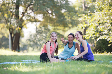 Fototapeta premium Families with young Russian mother and daughter are talk about exercise. After practice yoga at the park finished. Health and Fitness concept