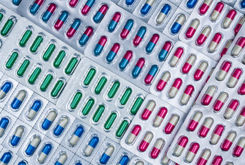 Full frame of colorful capsule pills in blister pack arranged with beautiful pattern. Pharmaceutical packaging. Medicine for infections disease. Antibiotic drug use with reasonable. Drug resistance.