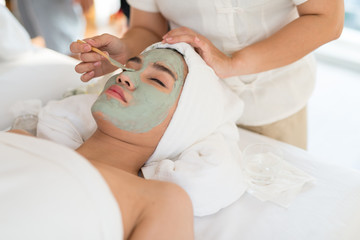 Obraz na płótnie Canvas A female therapist doing Facial Spa/Treatment Add moisture to the skin with Asian woman lying on a bed in spa salon.