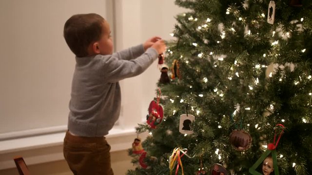 Slow motion shot of boys decorating their festive Christmas tree at night