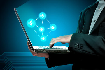Businessman holding laptop with money network
