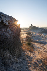 Sonnenaufgang mit Sonnenstern an einer Felswand