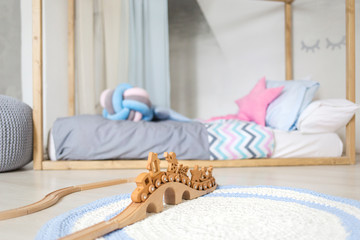 Photo of cosy and light child room interior. modern room for children at home. Interior scandinavian style. wooden magnetic train in the foreground