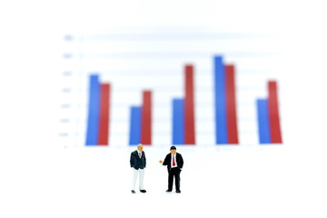 Miniature people : Businessman stand with Financial graphs analysis.