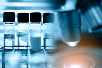 Microscope with lab glassware, science research and development concept 