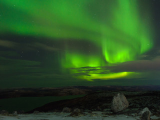 Fototapeta na wymiar Northern Lights, polar lights above the hills and tundra bay in winter.