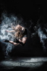 Girl dansing with flour on black background