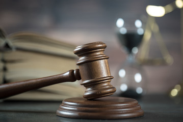 Law and Justice concept. Gavel of the judge, books, scales of justice. Brown background,  Courtroom theme.
