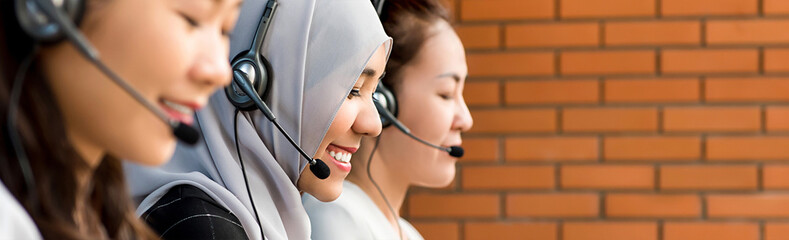 Beautiful Asian muslim woman working in call center with her team