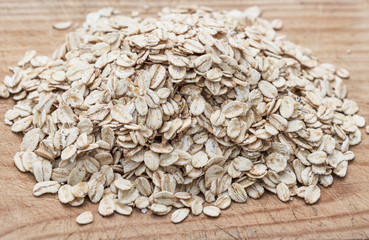 Oatmeal or oat flakes on wood board.   