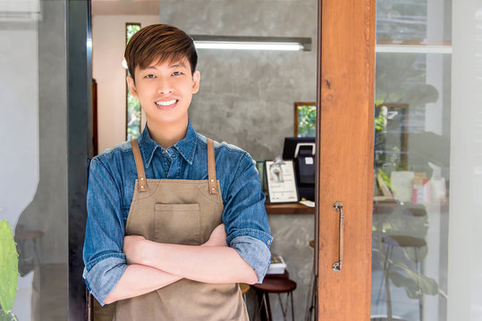 Young entrepreneur Asian man at front door of his own cafe