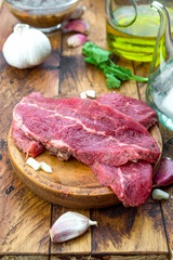 raw veal steaks on rustic wooden board