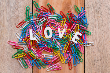 Valentine's day love Letter with series of colorful paper clips isolated on wooden board background with copy space.