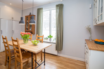 kitchen table with red tulips in cosy kitchen