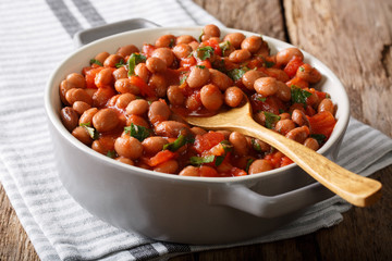 Vegetarian food Borlotti beans in tomato sauce with herbs close-up in a bowl. horizontal