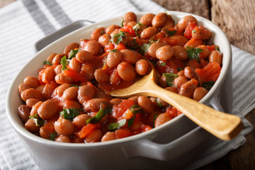 Organic Borlotti beans in tomato sauce with herbs close-up in a bowl. horizontal