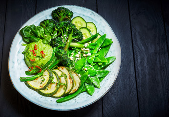 Buddha bowl with green vegetables on table