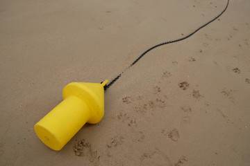 Yellow buoy forest on the sand on the shore of the sea