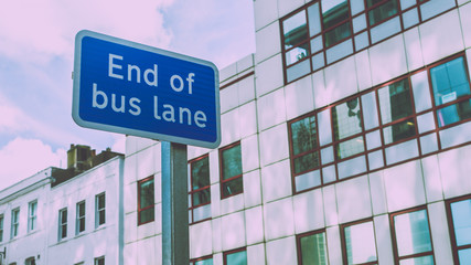 End of Bus Lane Sign with Modern Building in background, split toning shallow depth of field horizontal photography