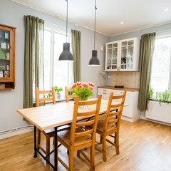 kitchen table in a kitchen with light grey walls and green curtains