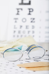 Eyeglasses for children on a eye chart close to eye pads.