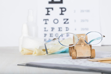 Eyeglasses for children on a eye chart close to eye pads.