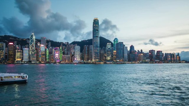 Hong Kong, China, day to night time lapse view of skyline and Victoria Harbour, zoom in.