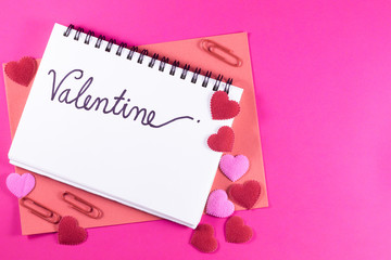 Valentine's day love letter with notebook on pink paper background with copy space