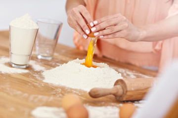 Young woman trying to make pierogi in kitchen