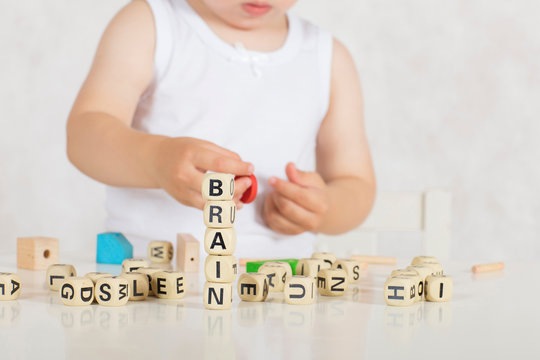 Small girl composes words from letters. Closeup